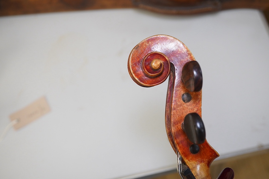 A late 19th century violin, bears fake Stradivarius label, cased, back measures 36cm. Condition - fair